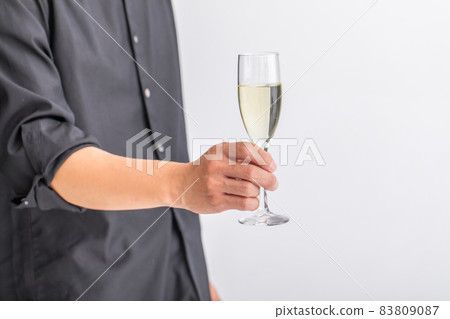 A man standing with a glass of champagne 83809087
