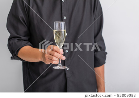 A man standing with a glass of champagne 83809088