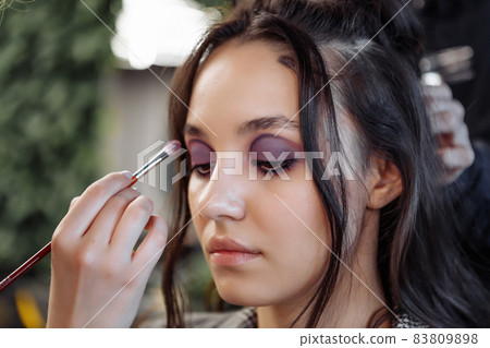 A young woman visited a beauty salon. Applying makeup and styling hair. 83809898