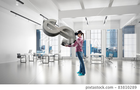 Girl in virtual reality mask experiencing virtual technology world. Mixed media 83810289