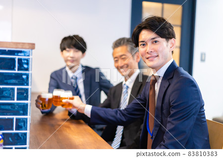 Three office workers toasting at the bar Three office workers toasting at the bar 83810383