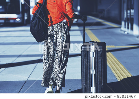 Woman walking with a carry case 83811467