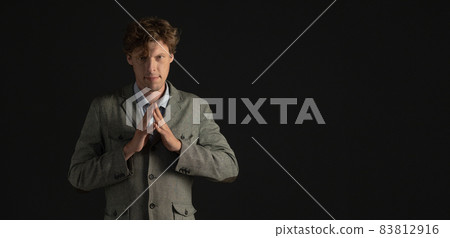 Confident businessman or scientist looks forward with folded fingers. Cut out on black background. Copy spase at right side Confident businessman or scientist looks forward with folded fingers. Cut out on black background. Copy spase at right side 83812916