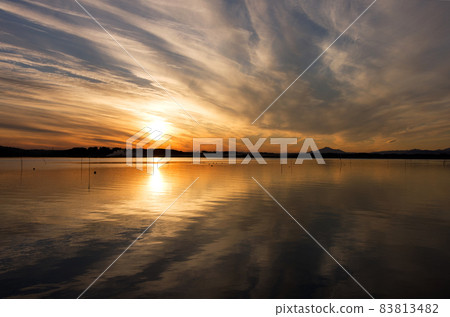 日沼夜景。橙色的太陽和雲彩倒映在水面上，倒映出美麗的景色，在雲層下可以看到筑波山的輪廓。 83813482