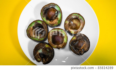 Contaminated tropical fruits. Bad Avocado Half. Vegan food cannot be eaten. Close up Overripe Tropical Fruits. Unhelthy food Concept. 83814289