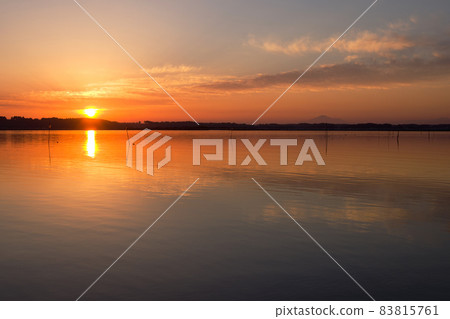 The setting sun of Hinuma. The clouds around the sun shine like a ring of Saturn, and the surface of the lake is dyed orange. The silhouette of Mt. Tsukuba The setting sun of Hinuma. The clouds around the sun shine like a ring of Saturn, and the surface of the lake is dyed orange. The silhouette of Mt. Tsukuba 83815761
