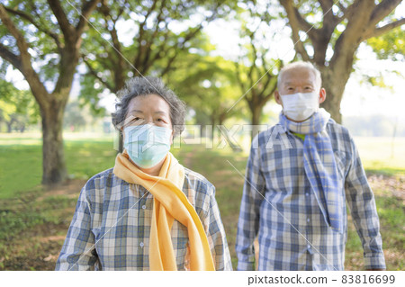 Senior couple  medical mask autumn walking park 83816699