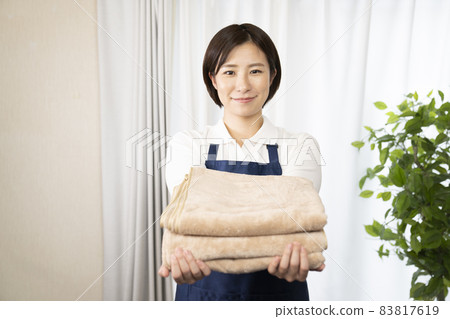 Woman housekeeper with a dry bath towel Woman housekeeper with a dry bath towel 83817619