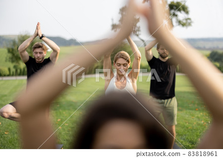 People practicing yoga on fitness mats on lawn People practicing yoga on fitness mats on lawn 83818961
