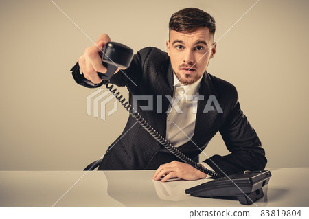 Portrait of attractive businessman holding telephone in his hand 83819804