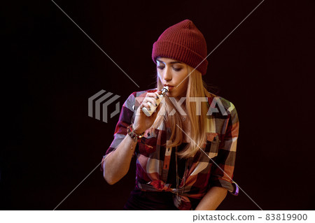 young woman smoking electronic cigarette young woman smoking electronic cigarette 83819900