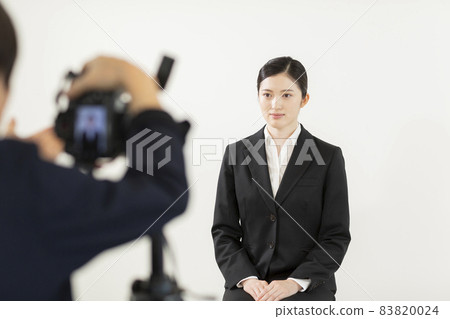 一個穿著西裝的女人在攝影棚裡開槍 83820024