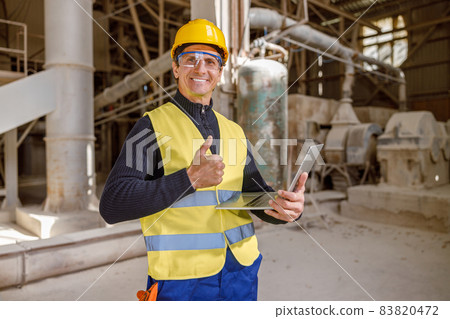 Joyful male worker holding laptop and doing thumbs up gesture Joyful male worker holding laptop and doing thumbs up gesture 83820472