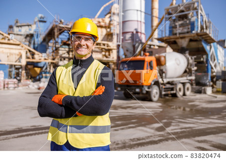 Cheerful man engineer standing outdoors at factory 83820474