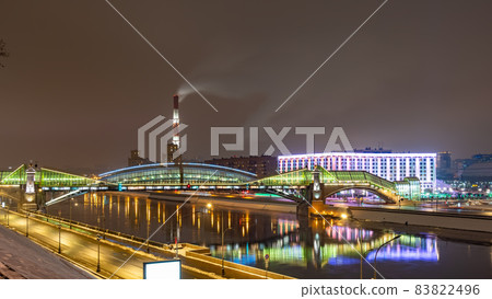View of the colorful Bogdan Khmelnitsky bridge illuminated at night reflecting in the Moskova river. Moscow, Russia 83822496