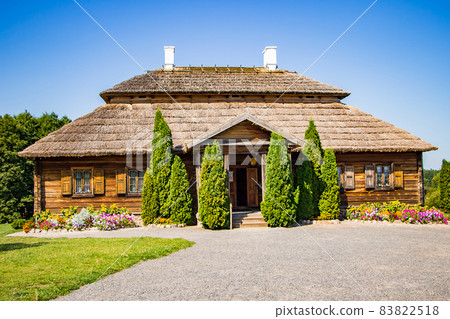 Old wooden house on a summer sunny day. Beautiful view of the village building with flowers. Old wooden house on a summer sunny day. Beautiful view of the village building with flowers. 83822518