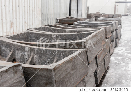 Cast iron tubing reinforced concrete cast products for lining distillation tunnels and underground structures are stored in the warehouse of the industrial plant 83823463