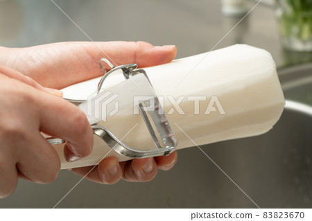 Peel radish with a peeler Peel radish with a peeler 83823670