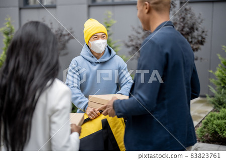 Businesspeople taking order from courier in city 83823761