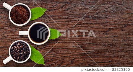 Coffee beans, ground coffee, coffee water, in a glass on wood with space top view Coffee beans, ground coffee, coffee water, in a glass on wood with space top view 83825390