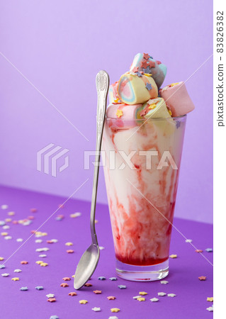Milkshake with fruit syrup and multicolored marshmallows 83826382