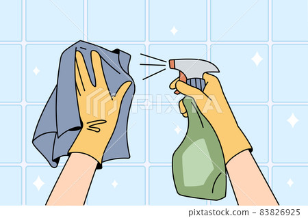 Housekeeper in gloves clean surface with spray  83826925
