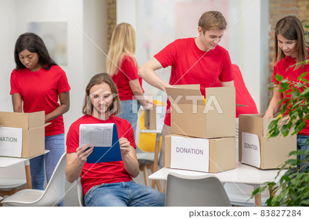Volunteers working in a sorting point and looking busy Volunteers working in a sorting point and looking busy 83827284