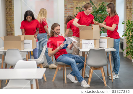 Volunteers working in a sorting point and looking busy Volunteers working in a sorting point and looking busy 83827285