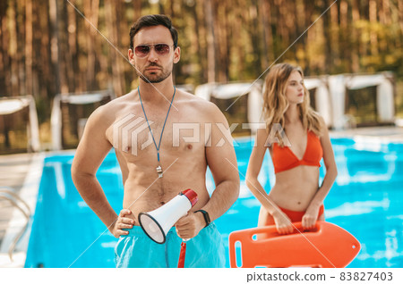 Two pool lifeguards standing near the public pool 83827403