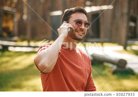Attractive young adult man communicating by smartphone Attractive young adult man communicating by smartphone 83827933