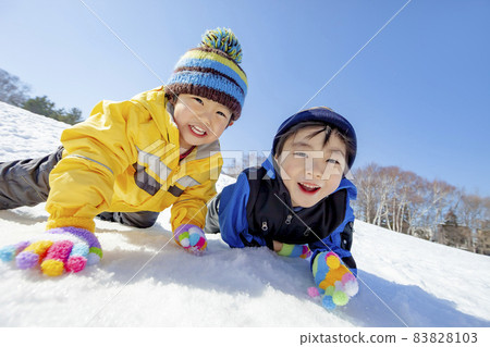 Kids playing in the snowy park Kids playing in the snowy park 83828103
