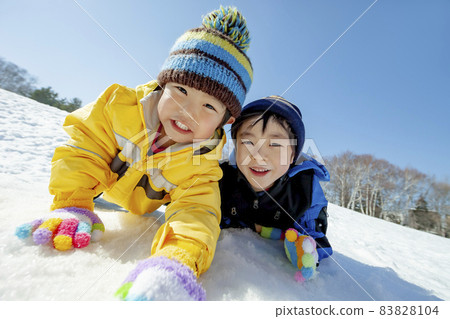 Kids playing in the snowy park 83828104