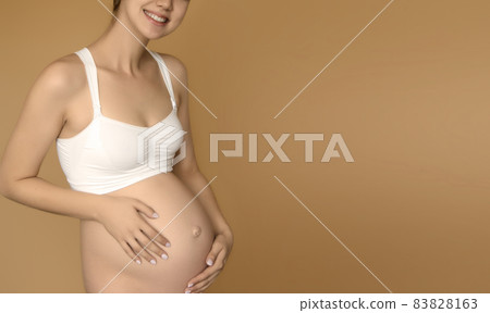 Beautiful pregnant young woman in clothes for 83828163