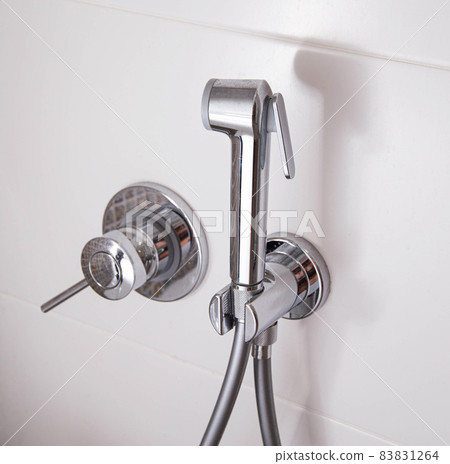 Modern hygienic shower in the toilet for washing and caring for the genitals, close-up. 83831264
