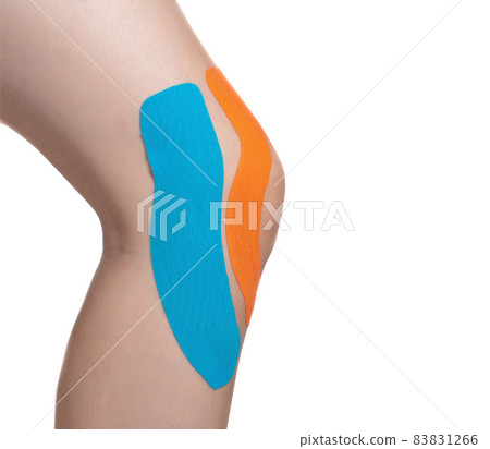 Female knee joint with orange and blue tape for microcirculation and joint fixation. White background, isolate, close-up Female knee joint with orange and blue tape for microcirculation and joint fixation. White background, isolate, close-up 83831266