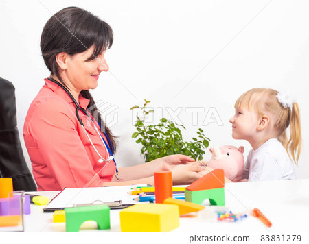 A caucasian woman, a pediatrician, a psychotherapist, is making contact with a girl patient, a child of 3-4 years old. Copy space for text A caucasian woman, a pediatrician, a psychotherapist, is making contact with a girl patient, a child of 3-4 years old. Copy space for text 83831279