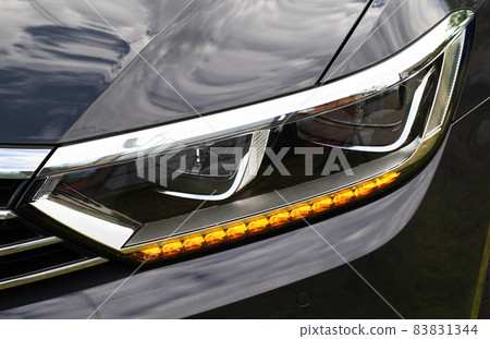 Economical and modern car headlight with LED adaptive light. Close-up, illuminate Economical and modern car headlight with LED adaptive light. Close-up, illuminate 83831344