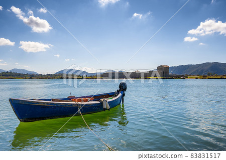 Boat on sea. Old blue painted fishing boat tied with rope at seacoast 83831517