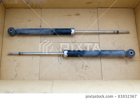 The old shock absorber in the crate box that was removed from a small sedan after being inspected. The old shock absorber in the crate box that was removed from a small sedan after being inspected. 83832367