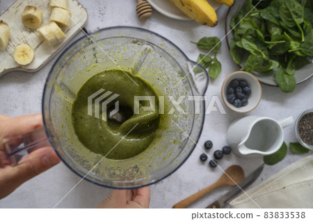 Cooking, preparring green spinach, banana and blueberry smoothie. Female hands, top view. Step by step recipe. Cooking, preparring green spinach, banana and blueberry smoothie. Female hands, top view. Step by step recipe. 83833538