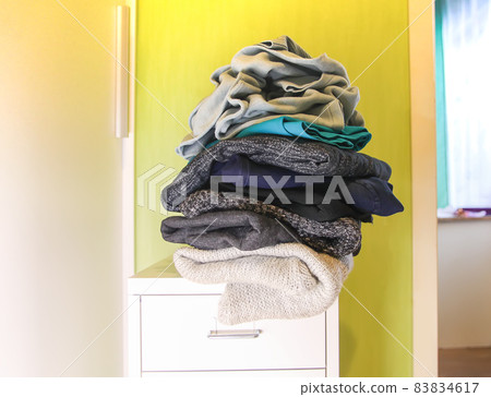 Home wardrobe with different clothes in disorder. Small space organization 83834617