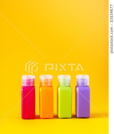 Colorful plastic bottles for skincare products or different purposes on yellow background Colorful plastic bottles for skincare products or different purposes on yellow background 83834677