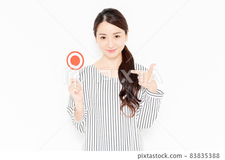 A casually dressed woman in an OK pose 83835388