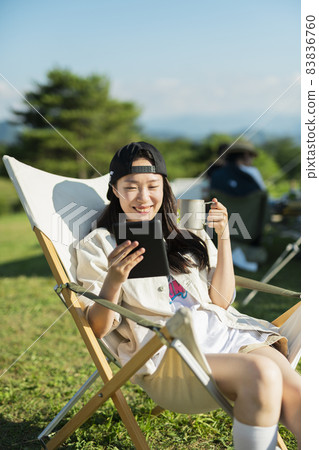A woman watching a video at a campsite 83836760