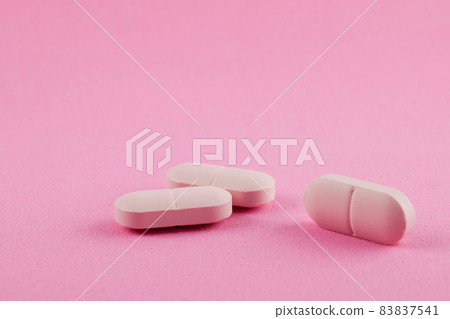 Pink pills on pink background. Women health Pink pills on pink background. Women health 83837541