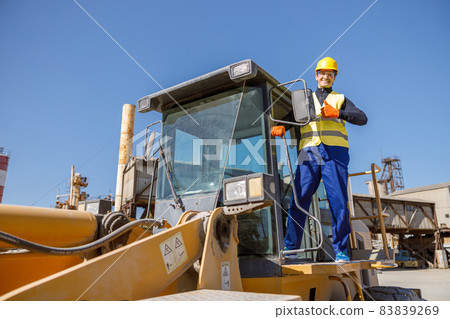 Cheerful male worker standing on industrial cabin 83839269