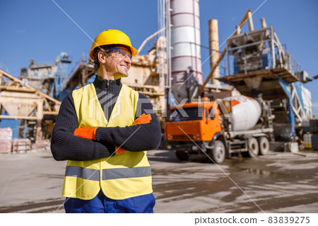 Cheerful male engineer standing outdoors at industrial site Cheerful male engineer standing outdoors at industrial site 83839275