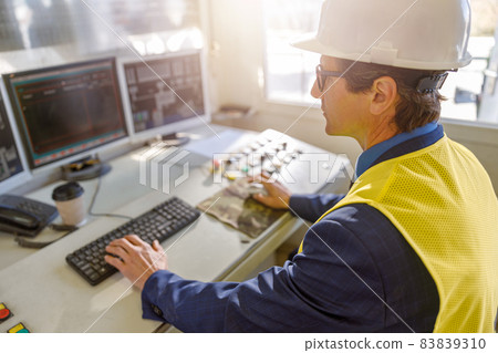 Male worker using computers at manufacturing plant Male worker using computers at manufacturing plant 83839310