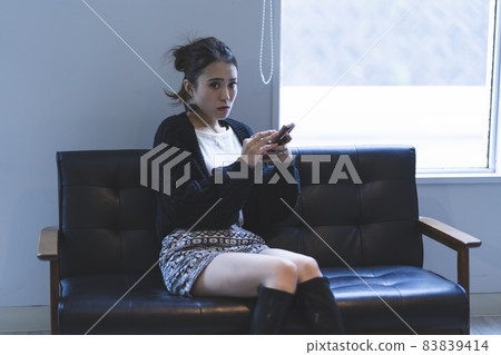 Cool lady using a smartphone Cool lady using a smartphone 83839414