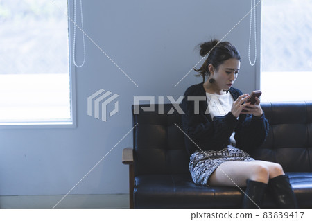 Cool lady using a smartphone Cool lady using a smartphone 83839417